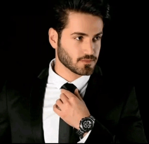 Man In Suit Adjusting Tie With Arabic Writing Above GIF