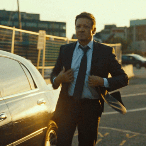 A Man In A Suit And Tie Adjusts His Tie GIF