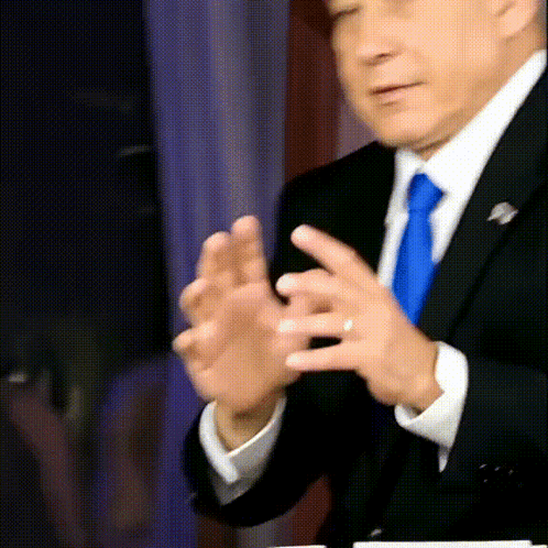 A Man In A Suit And Tie Applauds With His Hands GIF
