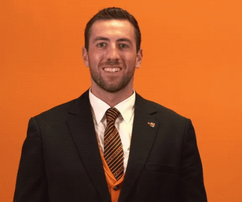 A Man In A Suit And Tie Covering His Mouth GIF