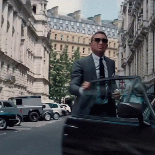 A Man In A Suit And Tie Gets Out Of A Car GIF