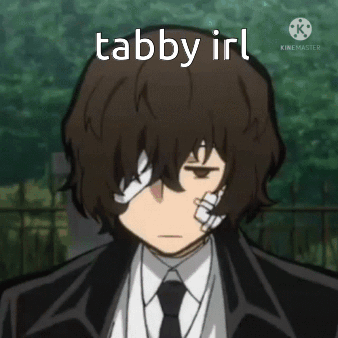 A Man In A Suit And Tie Has A Bandage On His Eye And The Words Tabby Irl Above Him . GIF