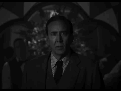 A Man In A Suit And Tie Has A Pattern On His Shirt GIF