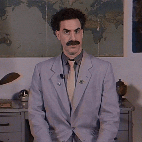 A Man In A Suit And Tie Has A Pin On His Jacket That Says ' A ' GIF