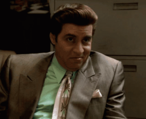 A Man In A Suit And Tie Has A Pink Pocket Square GIF