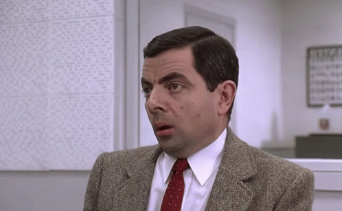 A Man In A Suit And Tie Has A Surprised Expression On His Face GIF