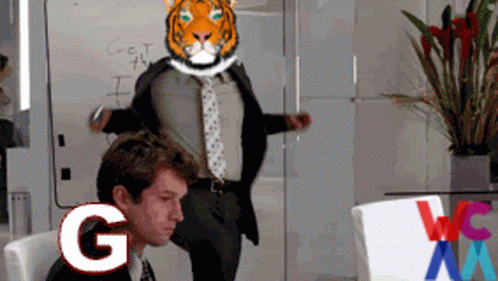 A Man In A Suit And Tie Has A Tiger Head On His Head And The Letter G Is Next To Him GIF