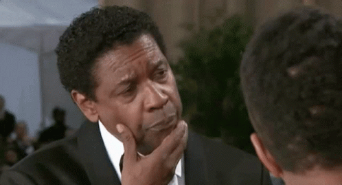 A Man In A Suit And Tie Has His Hand On His Neck GIF