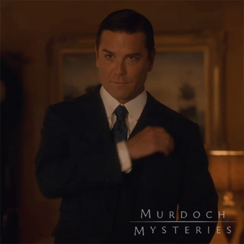 A Man In A Suit And Tie Has Murdoch Mysteries Written On His Chest GIF
