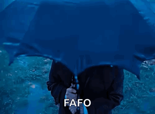 A Man In A Suit And Tie Holding A Blue Umbrella With The Word Fafo Written Below Him GIF