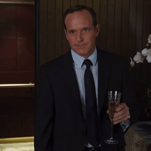 Man In Suit And Tie Holding Glass Of Wine GIF