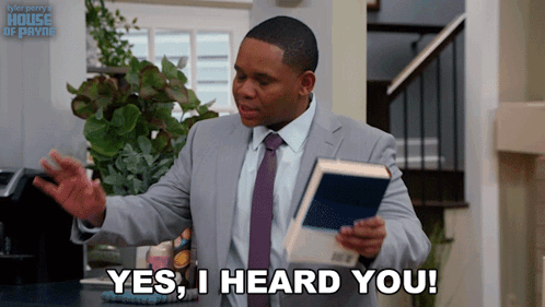 A Man In A Suit And Tie Holds A Book And Says " Yes I Heard You " GIF