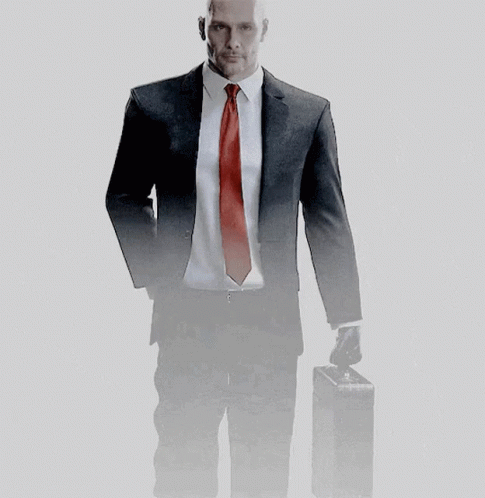 A Man In A Suit And Tie Holds A Briefcase GIF