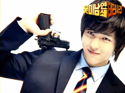 A Man In A Suit And Tie Holds A Gun In Front Of His Head GIF