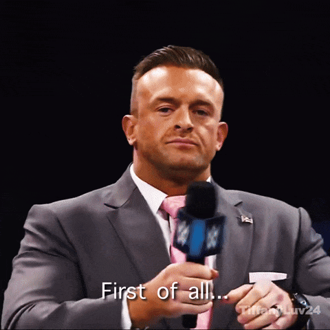 A Man In A Suit And Tie Holds A Microphone And Says " First Of All ... " GIF