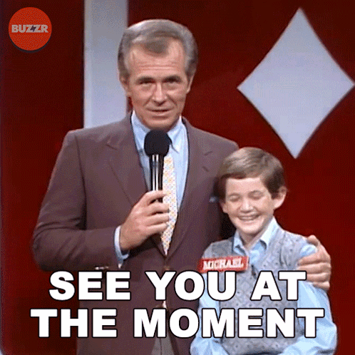 A Man In A Suit And Tie Holds A Microphone Next To A Boy With A Name Tag That Says Michael On It GIF