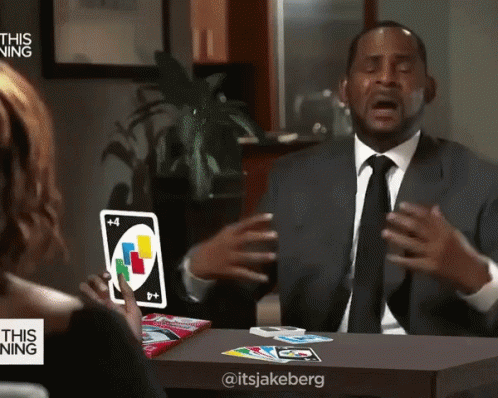 A Man In A Suit And Tie Holds A Uno Card GIF