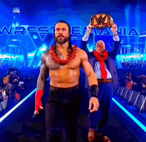 A Man In A Suit And Tie Holds A Wrestling Championship Belt GIF