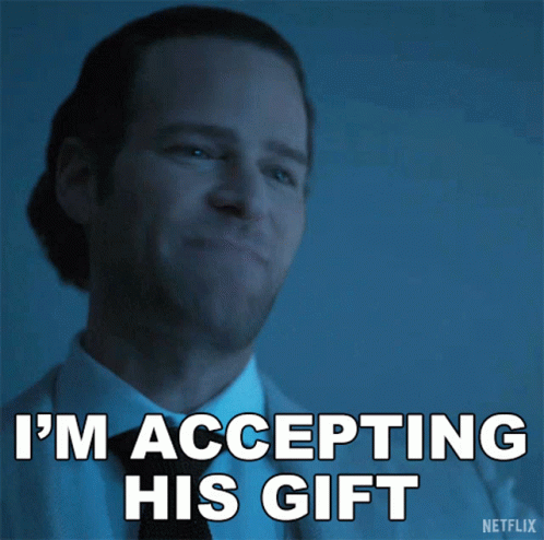 A Man In A Suit And Tie Is Accepting His Gift GIF