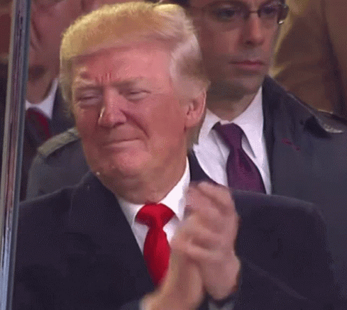 A Man In A Suit And Tie Is Applauding GIF