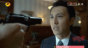 A Man In A Suit And Tie Is Being Shot With A Gun In A Room GIF