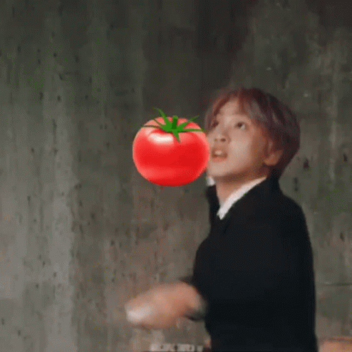 A Man In A Suit And Tie Is Blowing Up A Tomato . GIF