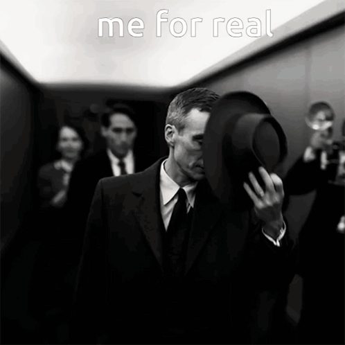 A Man In A Suit And Tie Is Covering His Face With His Hat And The Words " Me For Real " Are Above Him GIF