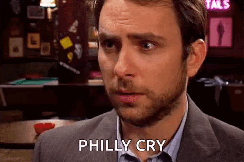A Man In A Suit And Tie Is Crying While Standing In Front Of A Bar . GIF