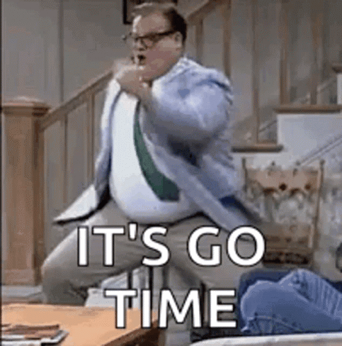 A Man In A Suit And Tie Is Dancing In A Living Room With The Words `` It 'S Go Time '' Above Him . GIF