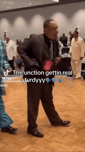 a man in a suit and tie is dancing in a room with a caption that says the junction gettin real sturdyy