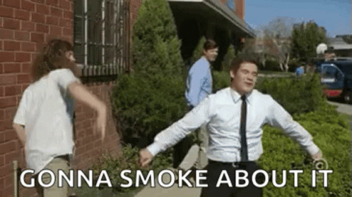 A Man In A Suit And Tie Is Dancing In Front Of A Brick Building While Another Man Looks On . GIF