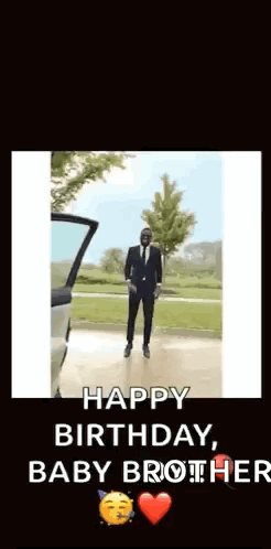 A Man In A Suit And Tie Is Dancing In Front Of A Car With The Words Happy Birthday Baby Brother . GIF