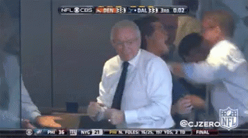 A Man In A Suit And Tie Is Dancing In Front Of A Cbs Nfl Broadcast GIF