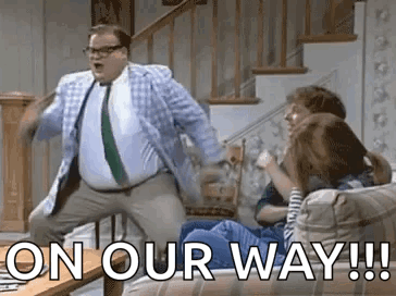 A Man In A Suit And Tie Is Dancing In Front Of A Group Of People . GIF