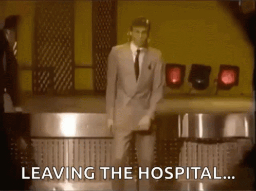 A Man In A Suit And Tie Is Dancing On A Stage With The Words Leaving The Hospital Behind Him . GIF