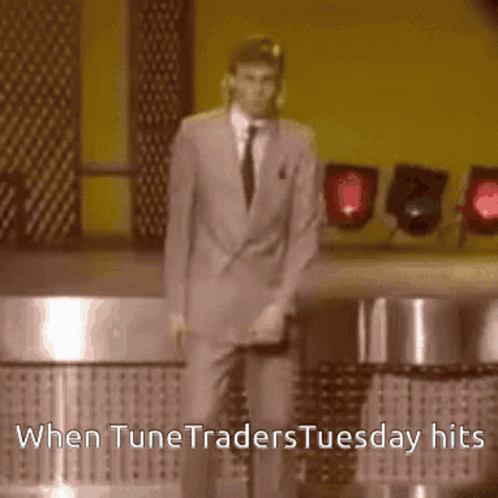 a man in a suit and tie is dancing on a stage with the words when tunetraders tuesday hits below him