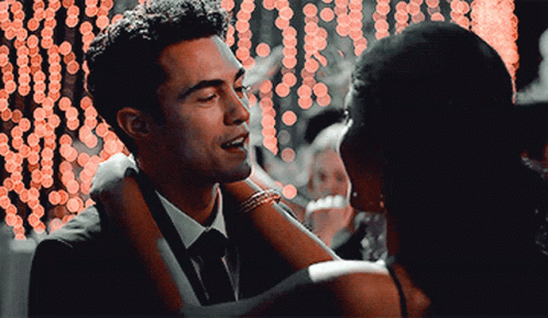 A Man In A Suit And Tie Is Dancing With A Woman GIF
