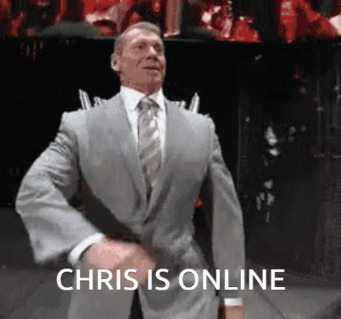 A Man In A Suit And Tie Is Dancing With The Words Chris Is Online Below Him GIF