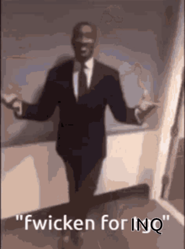 A Man In A Suit And Tie Is Dancing With The Words Fwicken For Inq Above Him GIF