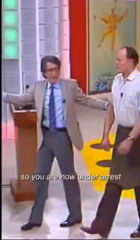 a man in a suit and tie is dancing with the words so you are now under arrest