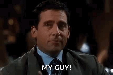 A Man In A Suit And Tie Is Drinking A Martini And Saying `` My Guy ! '' GIF
