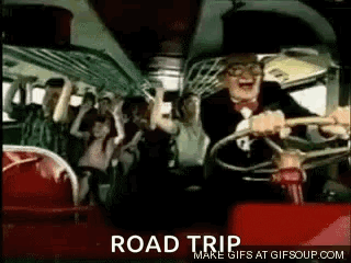 A Man In A Suit And Tie Is Driving A Bus With A Crowd Of People . GIF