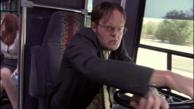 A Man In A Suit And Tie Is Driving A Bus With A Woman In The Back Seat GIF