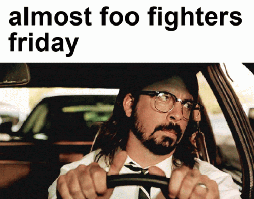 A Man In A Suit And Tie Is Driving A Car With The Words Almost Foo Fighters Friday Above Him GIF