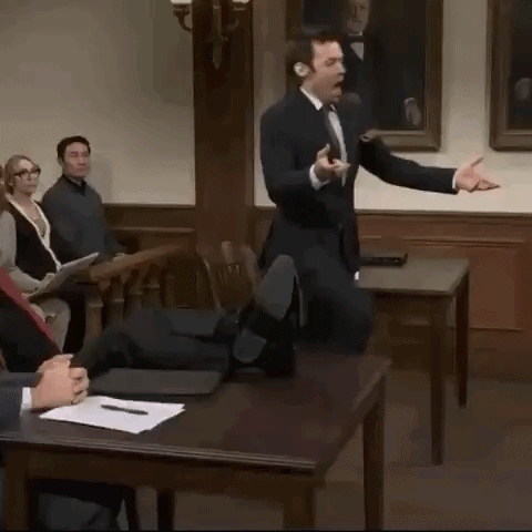 A Man In A Suit And Tie Is Giving A Presentation In Front Of A Group Of People GIF