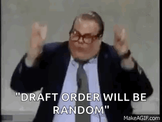 a man in a suit and tie is giving a speech and saying `` draft order will be random `` .