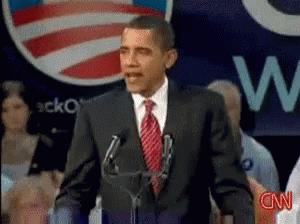 A Man In A Suit And Tie Is Giving A Speech In Front Of A Cnn Logo GIF