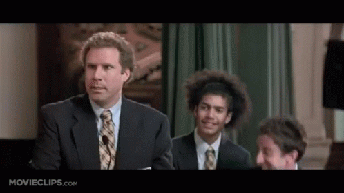 A Man In A Suit And Tie Is Giving A Speech In Front Of A Microphone . GIF