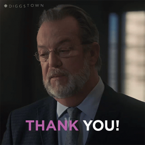 A Man In A Suit And Tie Is Giving A Thank You Sign GIF