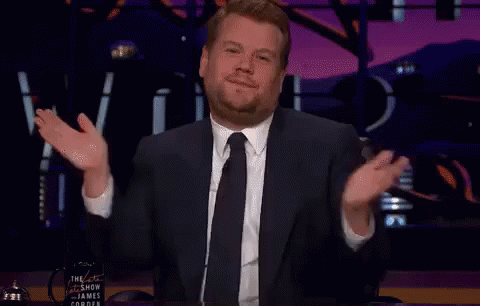 A Man In A Suit And Tie Is Giving A Thanks Gesture GIF
